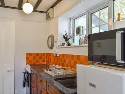 a kitchen with a sink and a refrigerator at Nessa Cottage - Uk47087 in Davidstow