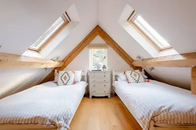 two beds in a attic bedroom with skylights at Little Trenant Barn on Helford River Near Constantine in Constantine