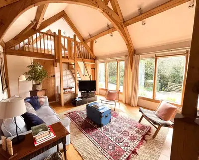 a living room with a couch and a tv at Little Trenant Barn on Helford River Near Constantine in Constantine