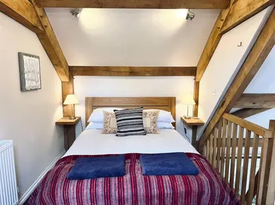 a bedroom with a large bed in a attic at Little Trenant Barn on Helford River Near Constantine in Constantine