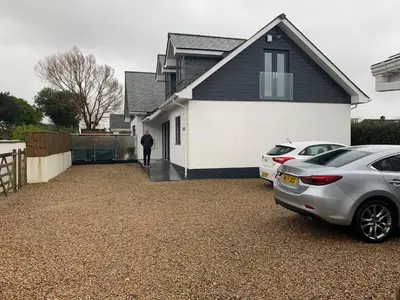 a man standing outside a house with two cars parked at Ashwood bed and breakfast in Truro