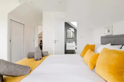 a bedroom with a large white bed with yellow pillows at Ashwood bed and breakfast in Truro