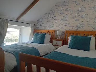 two beds sitting next to each other in a bedroom at Waterside Cottage in Penzance
