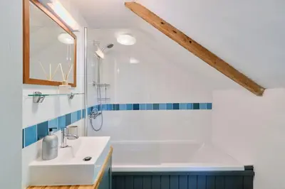 a bathroom with a white sink and a shower at Waterside Cottage in Penzance