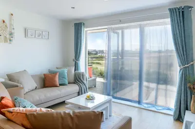 a living room with a couch and a large window at 6 Azure, Newquay in Newquay
