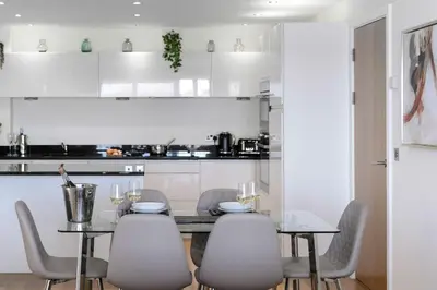 a kitchen with a dining room table and chairs at 6 Azure, Newquay in Newquay