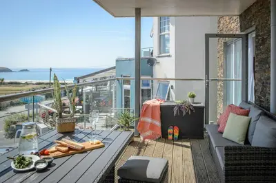 a balcony with a table and a view of the ocean at 6 Azure, Newquay in Newquay
