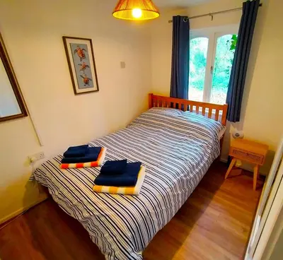 a bedroom with a bed with two towels on it at Rebels Retreat - 2-Bed Chalet nr St Ives & Hayle in St Ives
