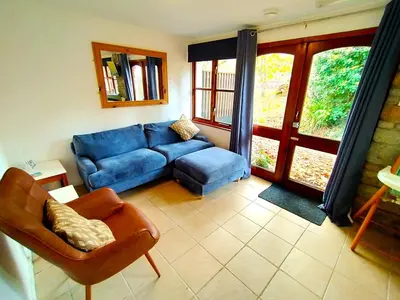 a living room with a blue couch and a chair at Rebels Retreat - 2-Bed Chalet nr St Ives & Hayle in St Ives