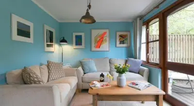 a living room with a couch and a table at Rebels Retreat - 2-Bed Chalet nr St Ives & Hayle in St Ives