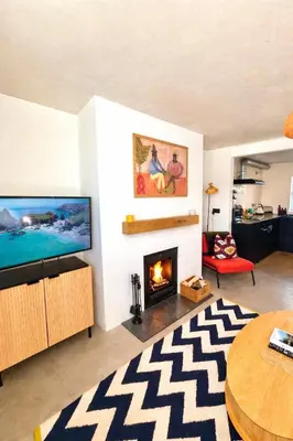 a living room with a television and a fireplace at Palms 1 Log Burner Private Courtyard Parking Central Newquay in Newquay