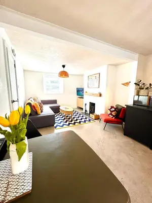 a living room with a couch and a table at Palms 1 Log Burner Private Courtyard Parking Central Newquay in Newquay
