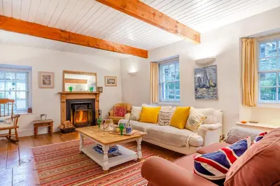 a living room with a couch and a fireplace at 5 Bed in Little Petherick oc-melynw in Little Petherick