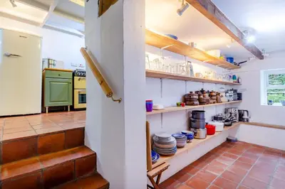 a kitchen with open shelves with dishes on them at 5 Bed in Little Petherick oc-melynw in Little Petherick