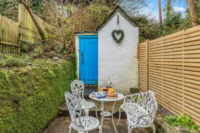 a patio with a table and chairs and a blue door at 5 Bed in Little Petherick oc-melynw in Little Petherick