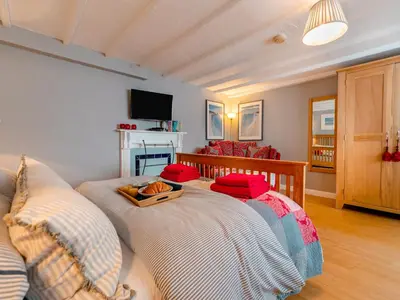 a living room with a bed and a couch at Riverside Barn in Newquay