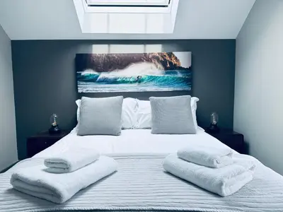 a bedroom with a large bed with two towels on it at Uno in the City - Urban Boutique Accommodation in Truro