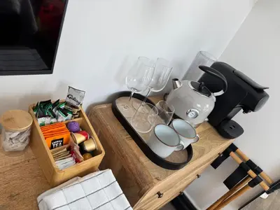 a table with a tea kettle and glasses on it at Uno in the City - Urban Boutique Accommodation in Truro