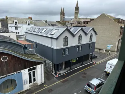a building with solar panels on top of a city at Uno in the City - Urban Boutique Accommodation in Truro