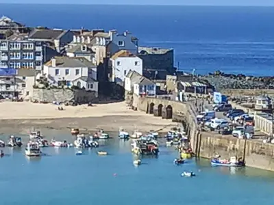 a group of boats in the water next to a beach at The Rookery in St Ives