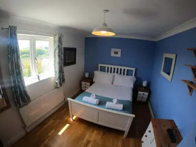 a bedroom with a bed with two stuffed animals on it at Gwel-an-Tansys in St. Agnes