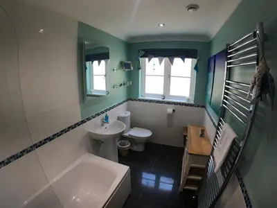 a bathroom with a sink and a toilet and a tub at Gwel-an-Tansys in St. Agnes