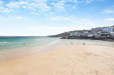 a beach with people walking on the sand and the ocean at 2 Bed in St. Ives oc-h28027 in St Ives