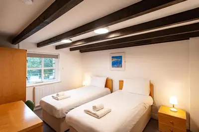 two beds in a small room with a window at Tregenna Castle Self Catering in St Ives