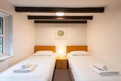 two twin beds in a room with a window at Tregenna Castle Self Catering in St Ives