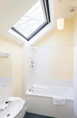 a bathroom with a white tub and a skylight at Tregenna Castle Self Catering in St Ives