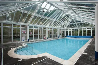 an indoor swimming pool with a glass ceiling at Tregenna Castle Self Catering in St Ives
