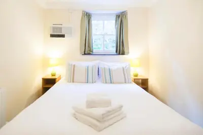 a bedroom with a white bed with towels on it at Tregenna Castle Self Catering in St Ives
