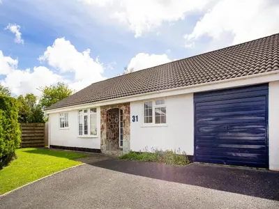 a white house with a blue garage door at 31 Lower Elms in Saint Minver