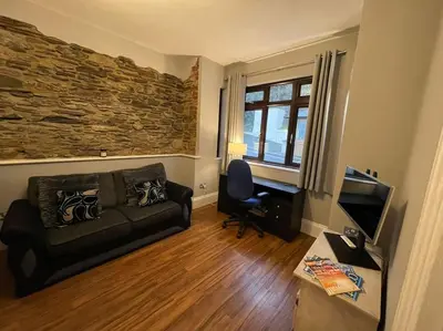 a living room with a couch and a desk at No1 Cottage Mevagissey in Mevagissey