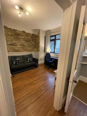 a living room with a couch and a desk at No1 Cottage Mevagissey in Mevagissey