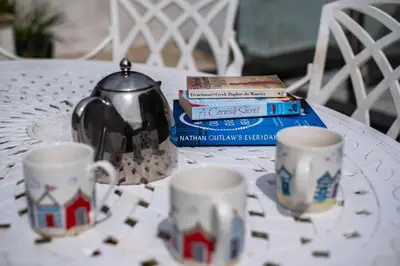 a table with two tea cups and a tea kettle at Derowen, Port Isaac Bay Holidays in Port Isaac