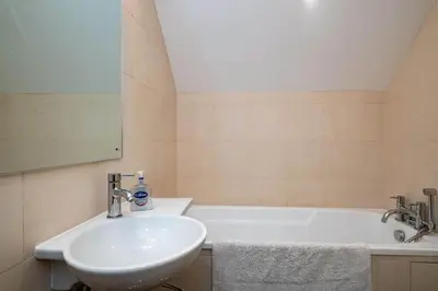a bathroom with a sink and a bath tub at Derowen, Port Isaac Bay Holidays in Port Isaac