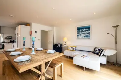 a living room with a table and a couch at Derowen, Port Isaac Bay Holidays in Port Isaac