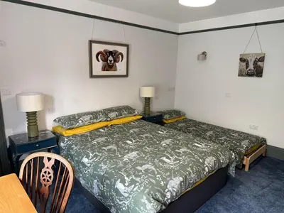 a bedroom with a bed and a table and chairs at Highermead House in Camelford