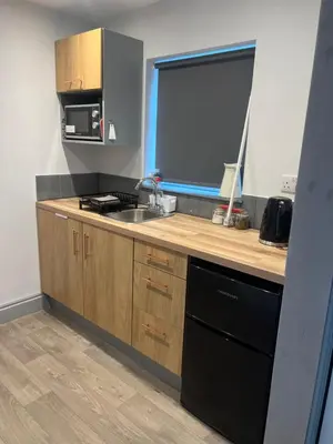 a kitchen with a counter with a sink and a microwave at Highermead House in Camelford