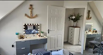 a bathroom with a sink and a vanity with a mirror at Perran Beach House in Perranporth