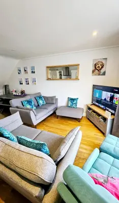 a living room with couches and a flat screen tv at Perran Beach House in Perranporth