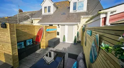 a backyard with a wooden fence and a pool at Perran Beach House in Perranporth