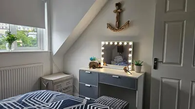 a bedroom with a sink and a mirror at Perran Beach House in Perranporth