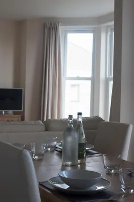 a dining room table with two bottles on top of it at Fairfield Apartment in St Ives