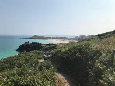 a dirt path leading to a beach with the ocean at Fairfield Apartment in St Ives