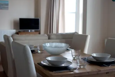 a dining room table with bowls and plates on it at Fairfield Apartment in St Ives
