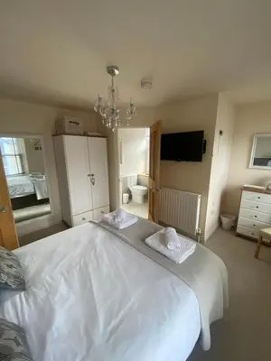 a bedroom with a large white bed with towels on it at Fairfield Apartment in St Ives