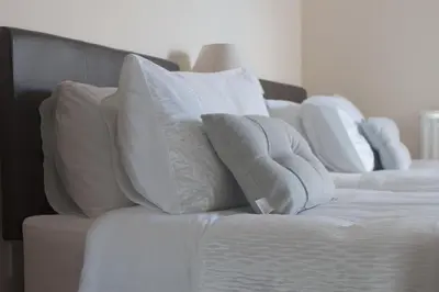 a group of white pillows on top of a bed at Fairfield Apartment in St Ives