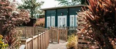 a fence in front of a house with a building at Holiday Home - St Austell in St Austell
